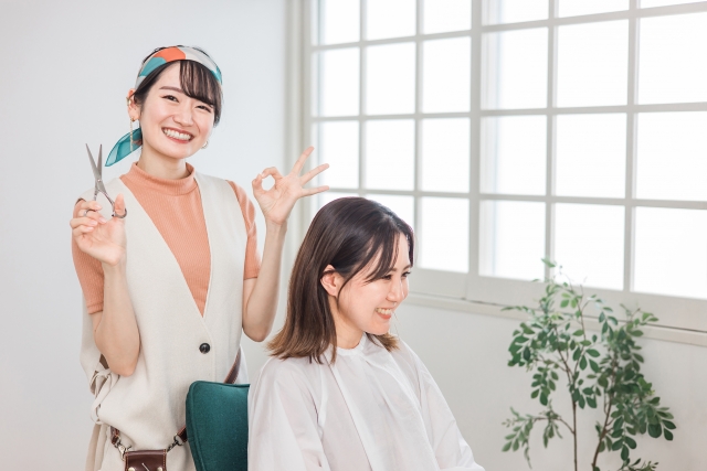 美容師の女性が指でOKサインを出している