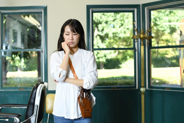 悩む美容師の女性