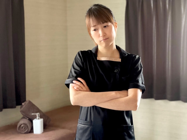 腕を組んで悩む女性