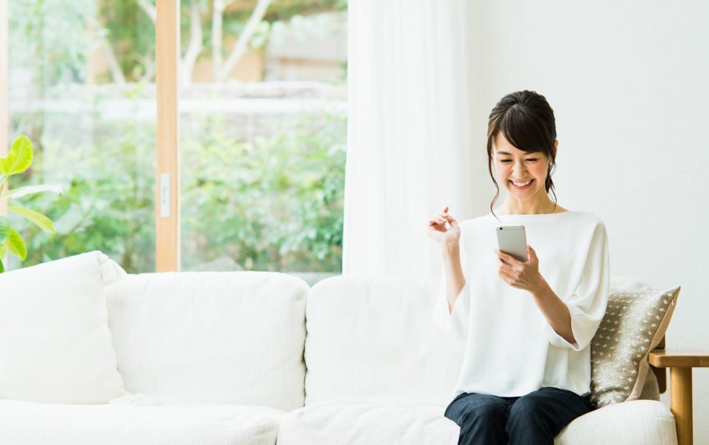 スマホを触る笑顔の女性