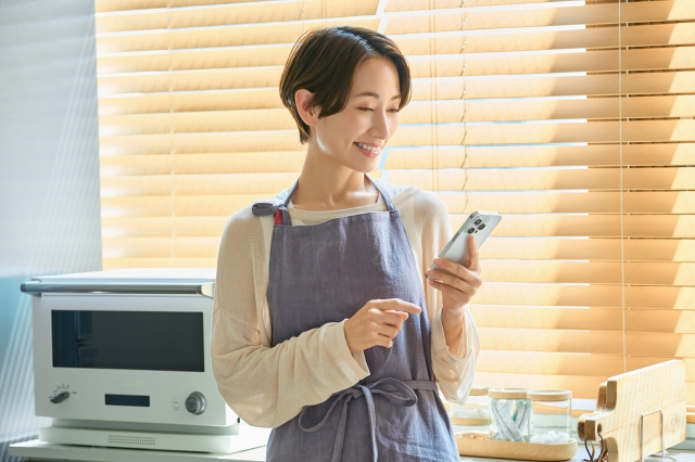 スマホを見る主婦