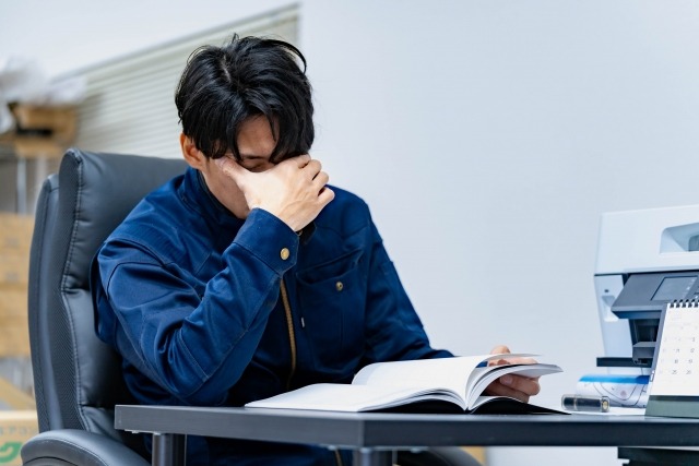 顔を伏せて悩む男性